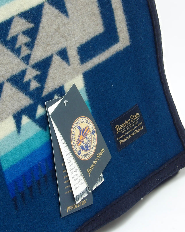 Pendleton Chief Joseph Blanket in Aegean featuring a traditional Native American-inspired geometric pattern with arrow motifs, folded neatly to show intricate design and soft wool texture. Tag View