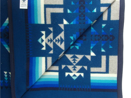 Pendleton Chief Joseph Blanket in Aegean featuring a traditional Native American-inspired geometric pattern with arrow motifs, folded neatly to show intricate design and soft wool texture, inside view