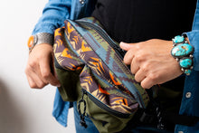 Load image into Gallery viewer, Person holding a Pendleton patterned bag with colorful designs, wearing a blue jacket and turquoise bracelet.
