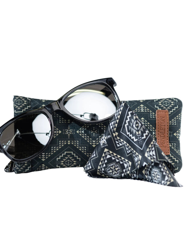 Sunglasses on a patterned pouch with a brown patch on a white background