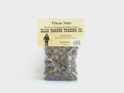 A clear plastic package containing roasted pinon nuts, with a label displaying the brand name, product name, and weight.