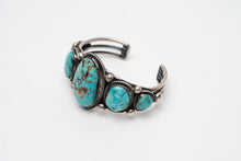 Load image into Gallery viewer, Right side view of a Native American bracelet bracelet with one large turquoise stone in the center with 2 more smaller turquoise stones on each side on a white background
