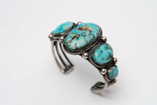 Load image into Gallery viewer, Top view of a Native American bracelet bracelet with one large turquoise stone in the center with 2 more smaller turquoise stones on each side on a white background
