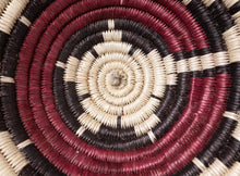 Load image into Gallery viewer, A vintage Navajo coiled basket with a starburst pattern in natural, red, and black tones, center close up of basket.
