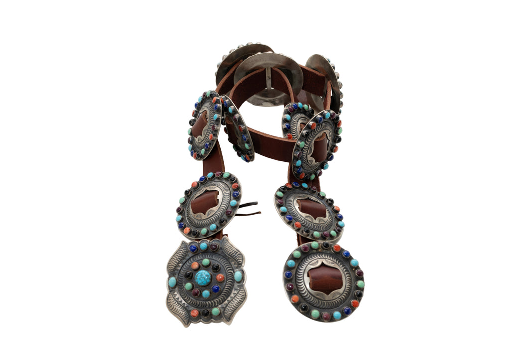 Decorative leather belt with colorful stone embellishments on a white background