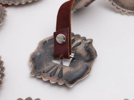 Close-up of the back of the silver buckle with leather strap on a white background