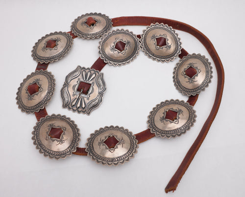Navajo Concho belt with 9 silver concho plates on brown leather on a white background