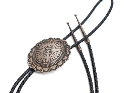 Navajo sterling silver bolo tie with two silver tips on a white background
