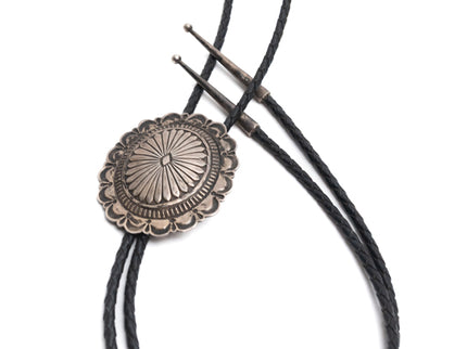 Vintage Navajo Silver Stamped Bolo-Tie with black braided leather cords on a white background