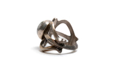 Load image into Gallery viewer, Side view of silver cast cut-out ring showcases a single, centrally set round white buffalo stone. Ring appears gold because of the natural patina
