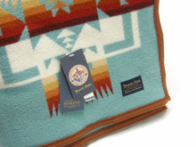 Load image into Gallery viewer, Pendleton Chief Joseph Blanket in aqua, featuring a traditional Native American-inspired geometric pattern with arrow motifs, folded neatly to show intricate design and soft wool texture
