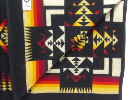 Pendleton Chief Joseph Blanket in black, featuring a traditional Native American-inspired geometric pattern with arrow motifs, folded neatly to show intricate design and soft wool texture. Inside View 