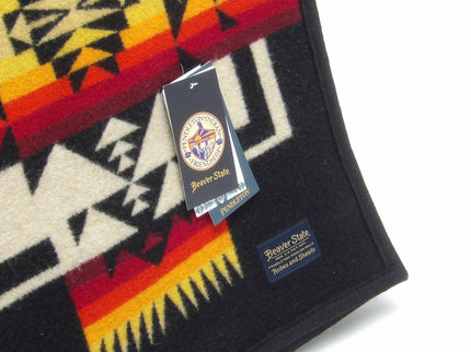 Pendleton Chief Joseph Blanket in Black, featuring a traditional Native American-inspired geometric pattern with arrow motifs, folded neatly to show intricate design and soft wool texture. tag view