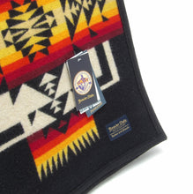 Load image into Gallery viewer, Pendleton Chief Joseph Blanket in Black, featuring a traditional Native American-inspired geometric pattern with arrow motifs, folded neatly to show intricate design and soft wool texture. tag view
