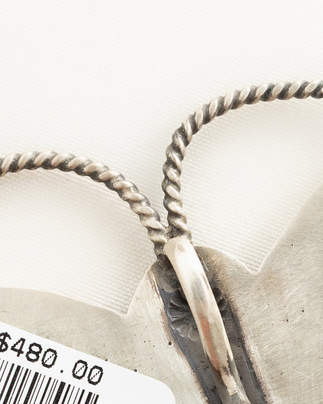 Close up of a native American pendant shaped like a butterfly. 