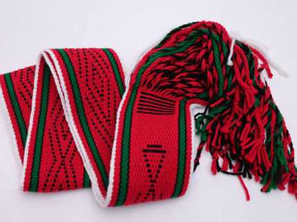 Dark red traditional sash with two green lines and black and white highlights folded in a v pattern on a white background