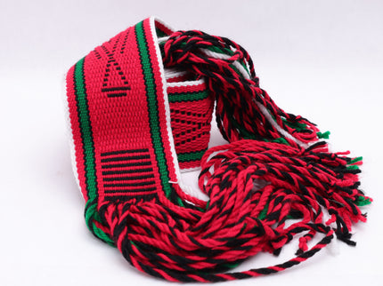 Dark red traditional sash with two green lines and black and white highlights rolled up on a white background
