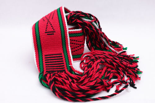 Dark red traditional sash with two green lines and black and white highlights rolled up on a white background