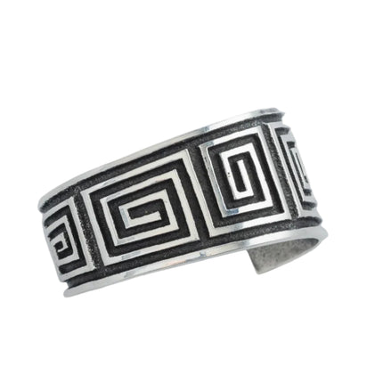 Navajo sterling silver bracelet with black oxidize maze pattern on a light gray background