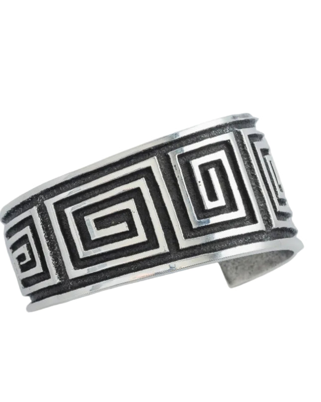 Navajo sterling silver bracelet with black oxidize maze pattern on a light gray background