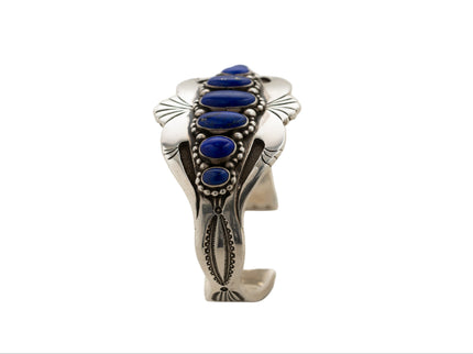 Side view of silver cuff bracelet with blue lapis stones on a white background