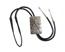 Load image into Gallery viewer, Full view of a bolo tie that has the design of silver spider with two turquoise stones as the body raised on a rectangular silver Bolo tie with spider web etching with a black leather cord and two silver tips
