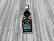 Load image into Gallery viewer, A silver pendant with a Navajo deity inlay pattern, featuring an array of colors including black, white, red, and blue.
