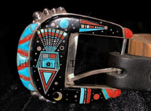Load image into Gallery viewer, A handcrafted Ranger belt buckle set featuring intricate inlay work. The design incorporates vibrant geometric patterns with black, turquoise, coral, and white inlays, inspired by Southwestern artistry. The bold and colorful patterns are framed by polished silver, enhancing the intricate details. The set is displayed on a black leather belt, resting on a textured dark background.
