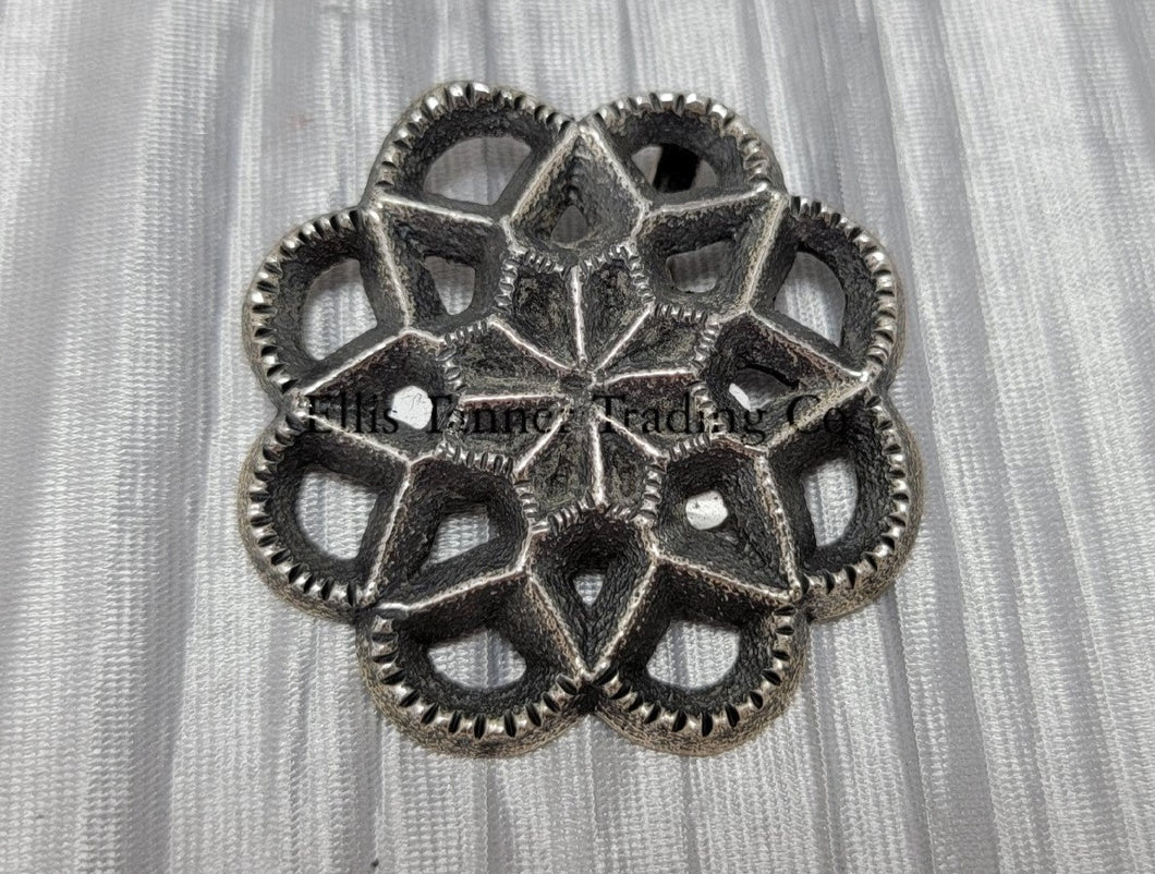 Silver Cut out sand cast, pendant displayed on top of a shiny silver cloth 