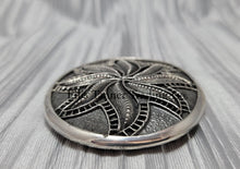 Load image into Gallery viewer, Silver sandcast, spiral flower, buckle 
 side view, placed on top of a silver cloth.
