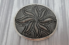 Load image into Gallery viewer, Silver sandcast, spiral flower, buckle placed on top of a silver cloth.
