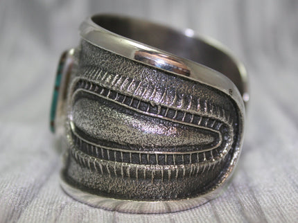 A bold sand-cast cuff featuring intricate textures and patterns, Side Profile. 
The design reflects a balance of rugged craftsmanship and refined artistry.