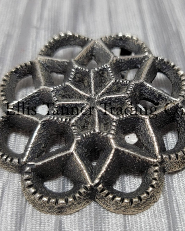 Silver Cut out sand cast, pendant displayed on top of a shiny silver cloth 