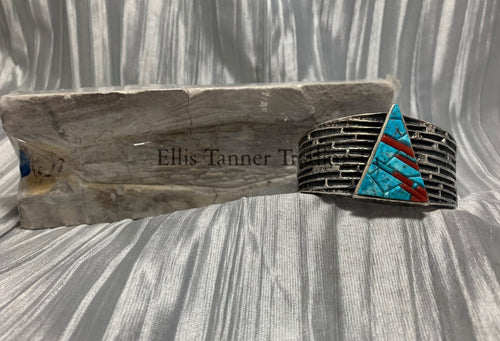 Displayed is a silver tufa cobbletone bracelet, on a silver shiny sheet 