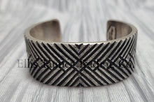 Load image into Gallery viewer, heavy, etched diamond designs front view of bracelet, displayed on top of a silver shiny cloth.
