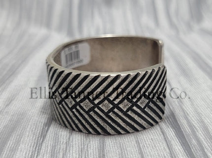 heavy, etched diamond designs front view of bracelet, displayed on top of a silver shiny cloth, side views
