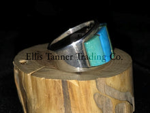 Load image into Gallery viewer, A silver-banded ring with blue and green stone inlays, displayed on a wooden piece, with the brand name &#39;Inner Trading&#39; visible.
