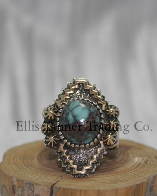Silver, with zigzag 14k overlay design with round Bisbee turquoise in center, on wooden display