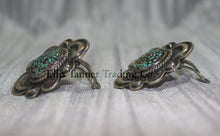 Load image into Gallery viewer, Silver stamped clip on earrings, with a center #8 Turquoise surrounded by a silver rope. side view on top of a silver sheet 
