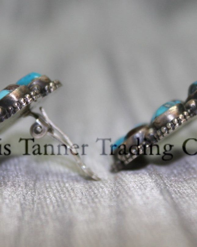 Cluster-style sterling silver clip-on earrings side view, displayed on a black card against a silver satin background.