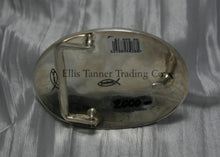 Load image into Gallery viewer, Oval shaped buckle, back side displayed on top of a shiny silver sheet 
