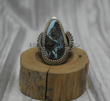 Load image into Gallery viewer, Tommy Jackson Black Diamond Turquoise Teardrop Stone silver overlay sides on top of a wooden display Front View 
