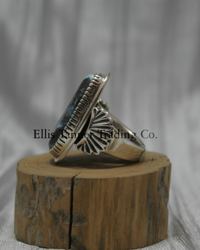 Tommy Jackson Black Diamond Turquoise side view, stamped overlay on top of band, On top of wooden display 