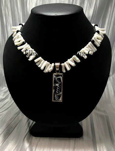 White coral choker with black onyx beads, in the center is a rectangular silver inlayed onyx and white coral pendant. 