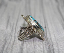 Load image into Gallery viewer, Side profile of a Bisbee Turquoise ring showcasing the raised oval turquoise stone with brown veining, set in a detailed silver bezel. the band’s craftsmanship is visible, emphasizing the ring&#39;s dimensional design.
