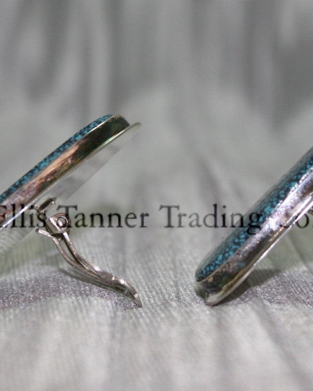 Silver slab-style clip-on earrings Side View set in sterling silver bezels, displayed against a textured silver background.
