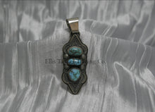Load image into Gallery viewer, A hand stamped silver pendant with three turquoise stones arranged vertically, each set in a bezel. The pendant features intricate geometric and linear stamped patterns on the silver, It has a sturdy silver bail at the top and an elongated, curved shape.
