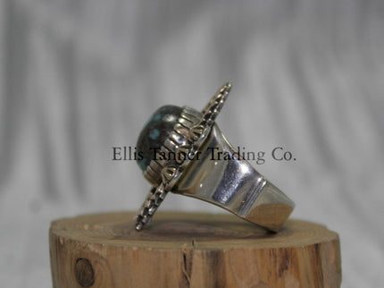 Silver ring, with zigzag 14k overlay design with round Bisbee turquoise in center, on wooden display side view,