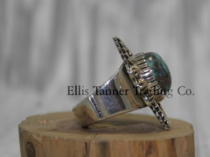 Silver Ring ,zigzag 14k overlay with round Bisbee turquoise in center, on a wooden display side 